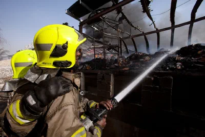 Fire fighter spraying water on a fire