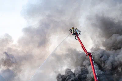 Firefighters using a cherry picker to fight a fire